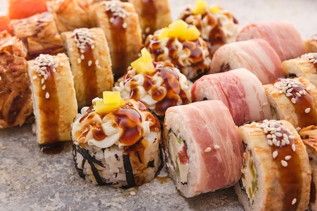 Traditionelle japanische Küche: Sushi. Auswahl an Sushi-Rollen auf einem Grau.