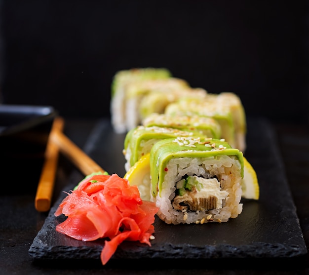 Traditionelle japanische Lebensmittel - Sushi, Brötchen und Sauce auf schwarzem Hintergrund.