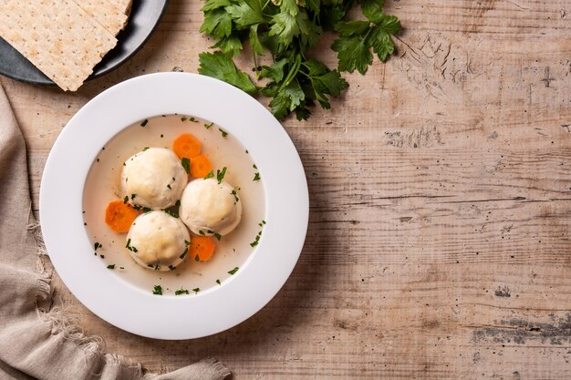 Traditionelle jüdische Matzenbällchensuppe auf Holztisch