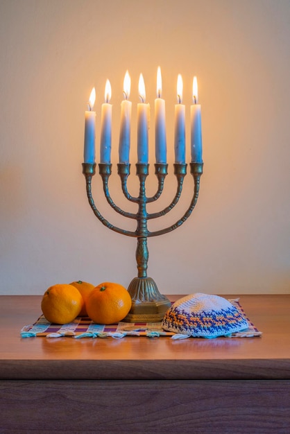 Traditionelle jüdische Menora mit brennenden Kerzen Kippah und einem Haufen Mandarinen