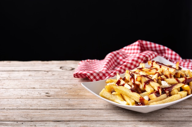 Traditionelle kanadische Poutine auf Holztisch