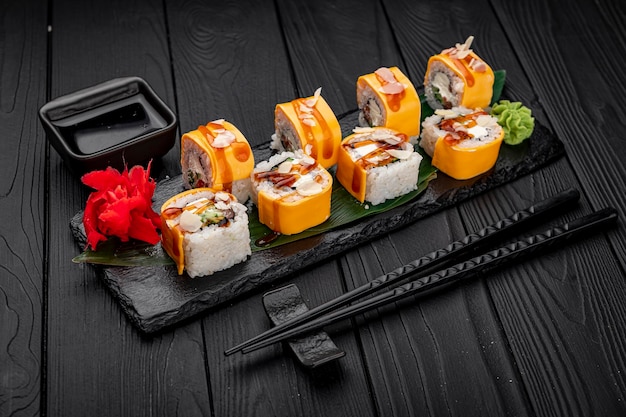 Traditionelle köstliche frische Sushi-Rolle auf schwarzem Hintergrund Sushi-Rolle mit Reis-Frischkäse-Lachs