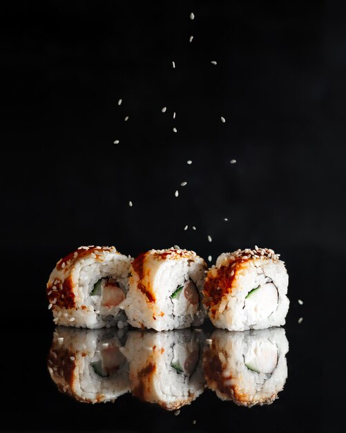 Traditionelle köstliche frische Unagi Syake Sushi-Rolle auf schwarzem Hintergrund mit Reflektion