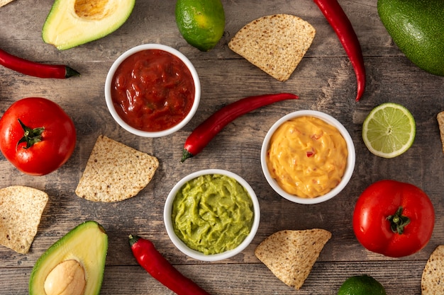 Traditionelle mexikanische Saucen. Guacamole, Chili-Pfeffer-Sauce und Käsesauce auf Holztisch