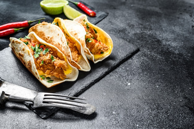 Traditionelle mexikanische Tacos mit Fleisch und Gemüse. Schwarzer Hintergrund. Draufsicht. Speicherplatz kopieren