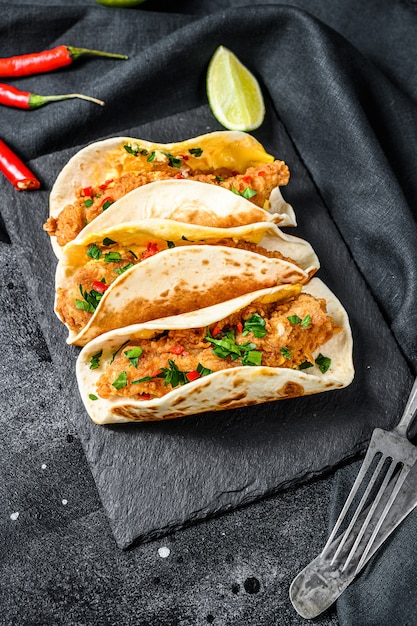 Traditionelle mexikanische Tacos mit Fleisch und Gemüse. Schwarzer Hintergrund.