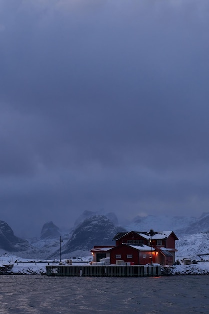 Traditionelle norwegische Fischerhütten und Boote auf der Insel Lofoten im Norden Norwegens. Wintersaison schlechtes Wetter