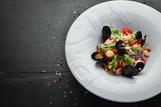 Traditionelle Pasta mit Meeresfrüchten auf einem Teller Muscheln Garnelen Tintenfisch Draufsicht Freier Kopierplatz