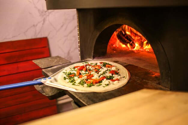 Traditionelle Pizza in der Restaurantküche in den Ofen geben