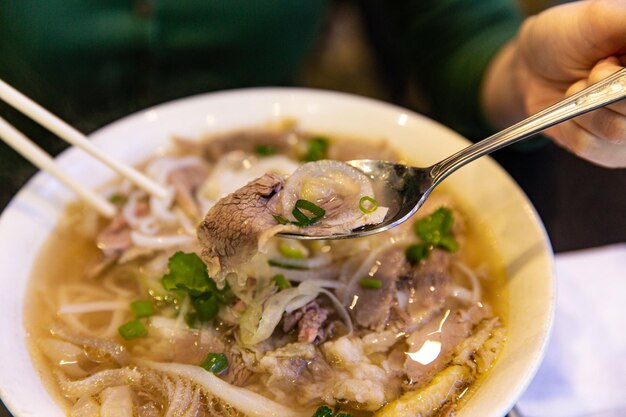 Traditionelle Rindfleischkombination Pho-Reisnudeln mit Rinderinnereien Zwiebel und Koriander essen mit ch