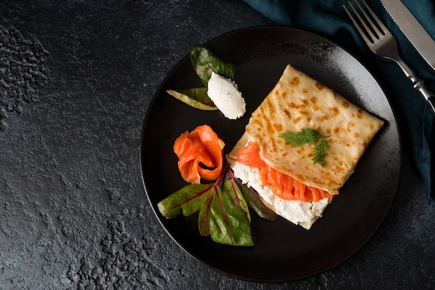 Traditionelle russische dünne pfannkuchen mit füllung, rotem fisch und frischkäse, draufsicht