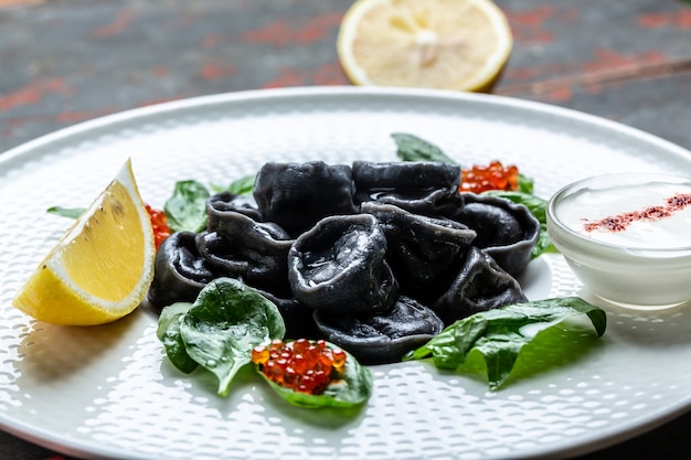 Traditionelle russische Pelmeni, Ravioli, Teigtaschen gefüllt mit Fisch und Kaviar. Hintergrund für Lebensmittelrezepte. Nahaufnahme.