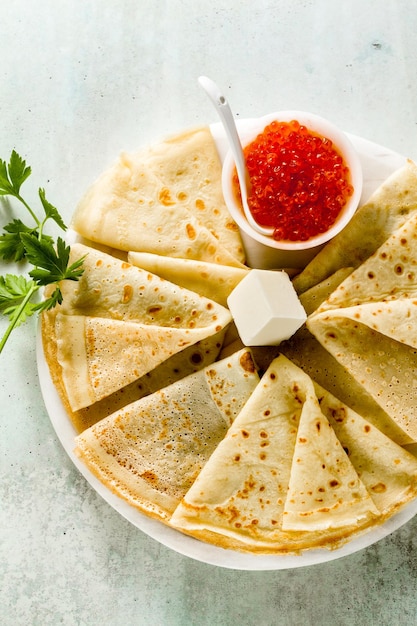 Traditionelle russische Pfannkuchen mit rotem Kaviar und Butter auf dem Tisch