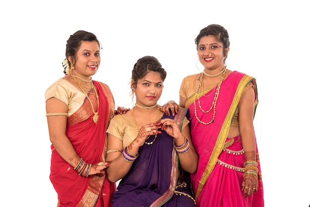 Traditionelle schöne indische junge Mädchen im Saree, der auf Weiß aufwirft