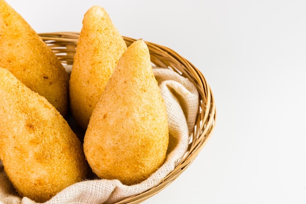 Traditionelle Snacks Chicken Coxinha, bekannt als Coxinha in Brasilien serviert in einem Korb Weißer Hintergrund Selektiver Fokus