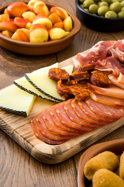 Traditionelle spanische Tapas. Kroketten, Oliven, Omelett, Schinken und Patatas Bravas auf Holztisch