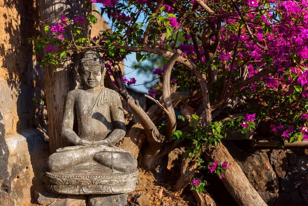 Traditionelle Steinskulptur von Buddha im Außenbereich im asiatischen Stil im Innenraum Bali Indonesien