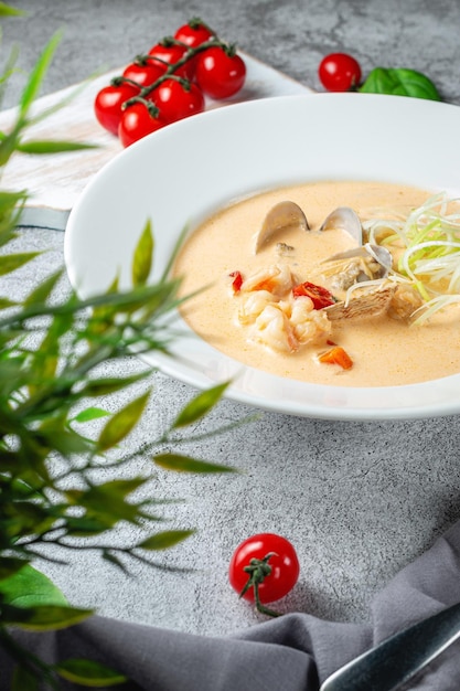 Traditionelle Suppe mit Rockfish und Muscheln, serviert in einem weißen Teller auf einem grauen Steintisch Restaurant-Menü