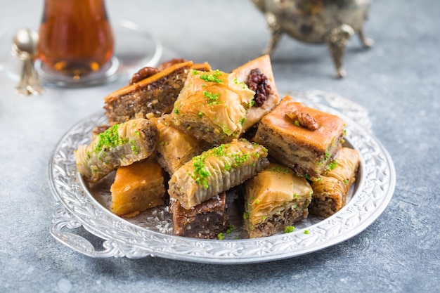 Traditionelle türkische Desserts Baklava mit Tee. Knusprige Baklava-Mix auf Silberplatte.