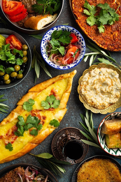 Foto traditionelle türkische küche, verschiedene gerichte und mezze-vorspeisen auf rustikalem hintergrund von oben pide lahmacun-fleischkebab, türkische fleischbällchen, süßes baklava und kunefe, küche aus dem nahen osten, draufsicht