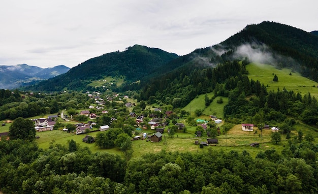 Traditionelle ukrainische Häuser im Bergdorf. Ländliche Landschaft mit Gebäuden, Bäumen.