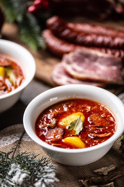 Traditionelle Weihnachtssauerkohlsuppe mit Kartoffeln, Wurst, geräuchertem Schweinefleisch und Pilzen