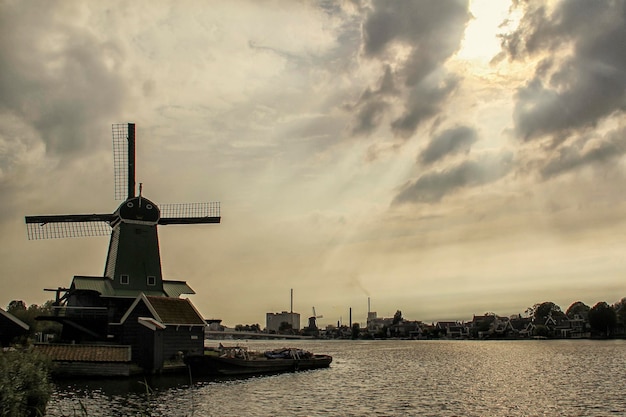 Foto traditionelle windmühle am fluss gegen den himmel