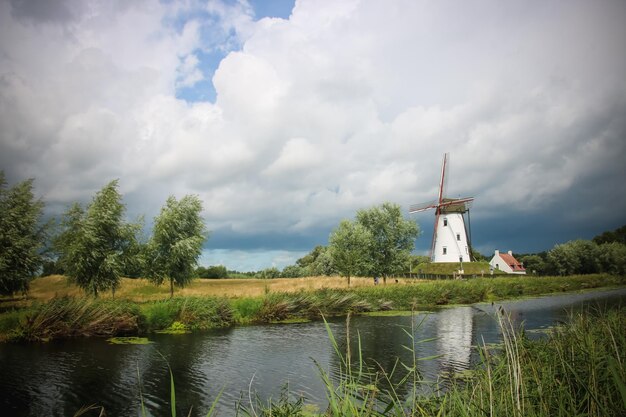 Traditionelle Windmühle am See gegen den Himmel