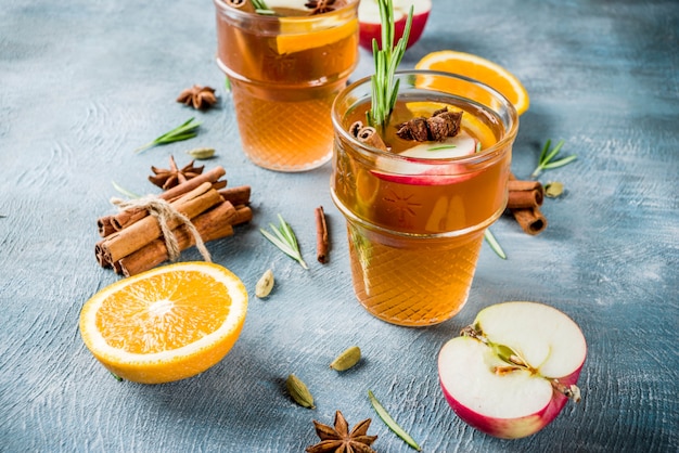 Traditionelle Wintergetränke, Glühweincocktail mit Weißwein, mit Gewürzen, Apfel, Orange