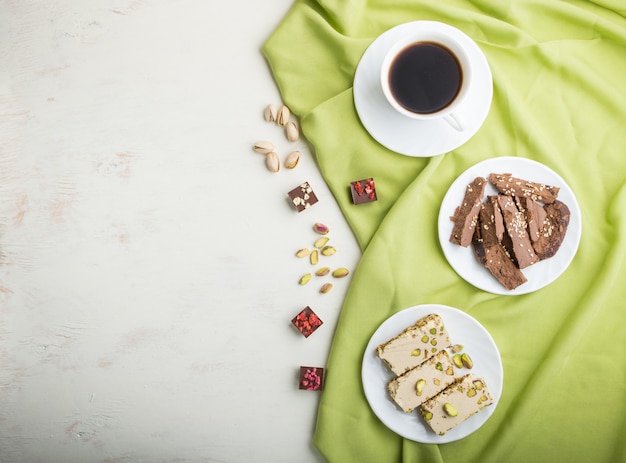 Traditioneller arabischer Bonbonsesam halva mit Schokolade und Pistazie und einem Tasse Kaffee. Ansicht von oben