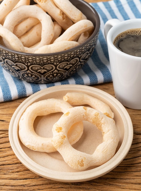 Traditioneller brasilianischer Polvilho oder Stärkekeks auf einer Schüssel mit Kaffee über Holztisch.