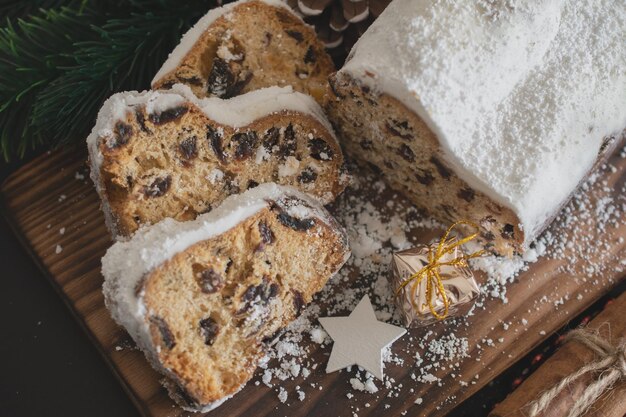 Traditioneller christstollen aus getrockneten früchten und nüssen mit puderzucker bestreut