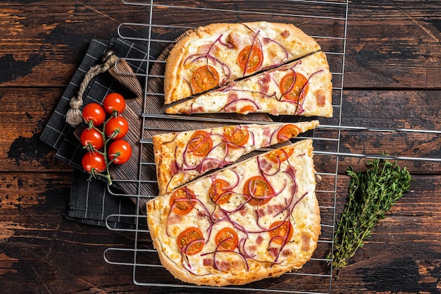 Traditioneller deutscher Flammkuchen oder Flammkuchen mit Frischkäse, Speck, Tomaten und Zwiebeln Holzhintergrund Draufsicht