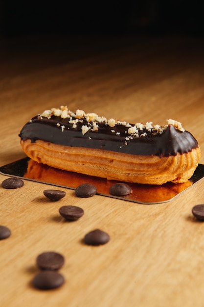 Traditioneller französischer Eclair mit Schokolade. Leckeres Dessert. Hausgemachte Kuchen Eclairs. Süßes Dessertgebäck gefüllt mit Sahne. Schokoladenglasur.