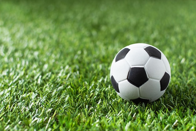 Traditioneller Fußball auf Gras-Fußballfeld in Sonnenstrahlen Fußball-Gewinner-Hintergrund