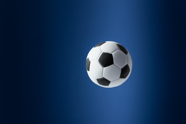 Traditioneller Fußball, der über blauem Hintergrund fliegt Fußballhintergrund für Design