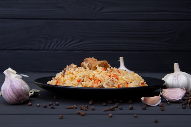 Traditioneller geschmackvoller Pilaf mit Knoblauch und Gewürzen auf Schwarzblech. Usbekistan Nationalgericht.