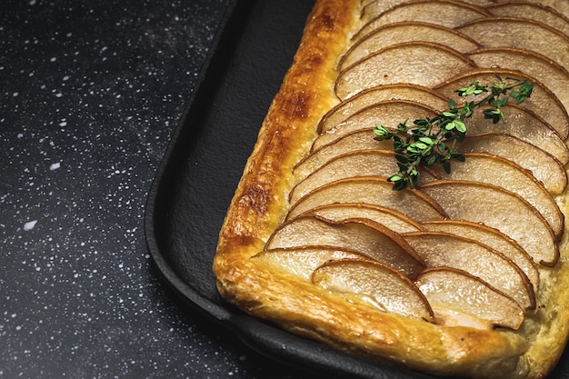 Traditioneller hausgemachter Bio-Apfelkuchen auf dunklem Tisch. Gesundes Foood-Konzept