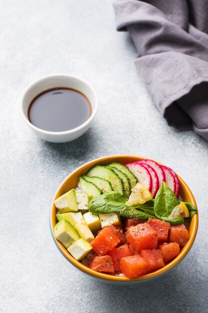 Traditioneller hawaiischer Poke-Salat mit Lachs, Avocado-Reis und Gemüse in einer Schüssel