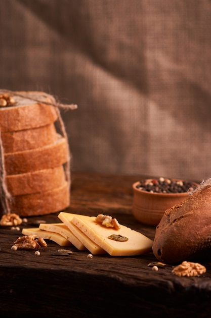 Traditioneller holländischer halb harter Käse diente nah oben auf ländlicher Tabelle mit dem Rausschmiß. Tiefenschärfe