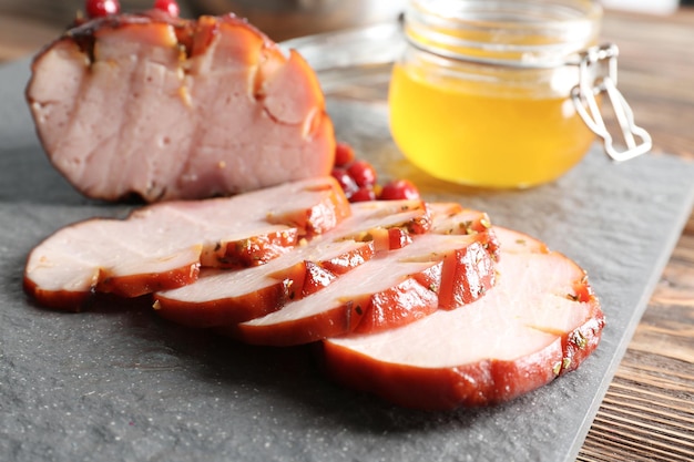 Traditioneller honiggebackener Schinken mit Preiselbeersauce auf Schieferplatte in der Nähe