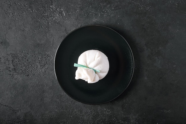 Traditioneller italienischer Burrata-Käse auf dunkler Platte auf Draufsichtkopienraum des Graphithintergrundes