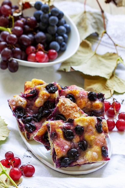 Foto traditioneller italienischer hefeteigkuchen mit traubenschiacciata und weintrauben auf einem licht