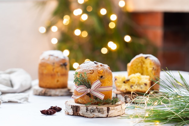 Traditioneller italienischer Weihnachtskuchen Panettone auf einem rustikalen Tisch mit festlicher Weihnachtsdekoration