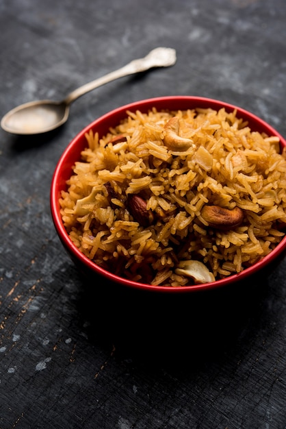 Traditioneller Jaggery-Reis oder Gur Wale Chawal in Hindi, serviert in einer Schüssel mit Löffel. selektiver Fokus