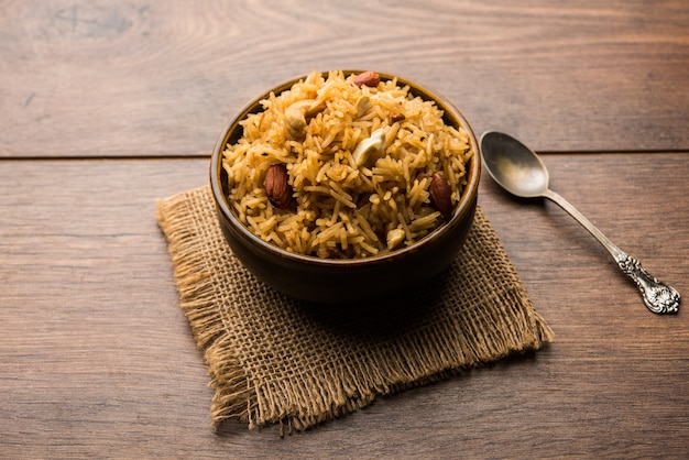 Traditioneller Jaggery-Reis oder Gur Wale Chawal in Hindi, serviert in einer Schüssel mit Löffel. selektiver Fokus