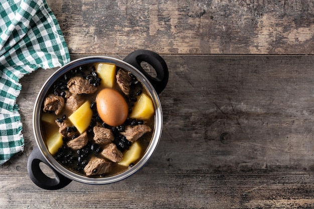 Traditioneller jüdischer Cholent auf Holztisch