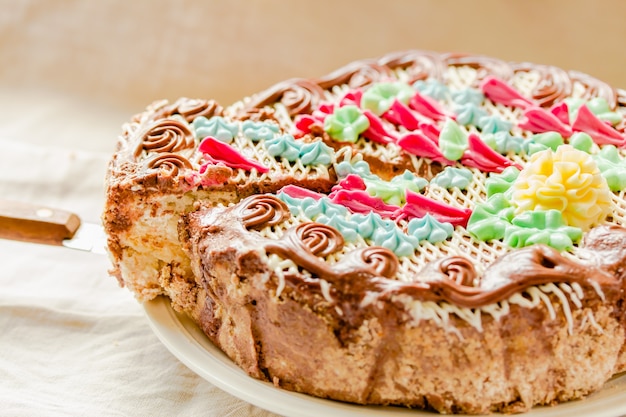 Traditioneller Kiewer Kuchen oder Daquoise Baiser ein Stück Kuchen mit Buttercreme auf dem Teller. Leckerer Feiertagskuchen auf einem weißen Hintergrund des Komfortleinens.