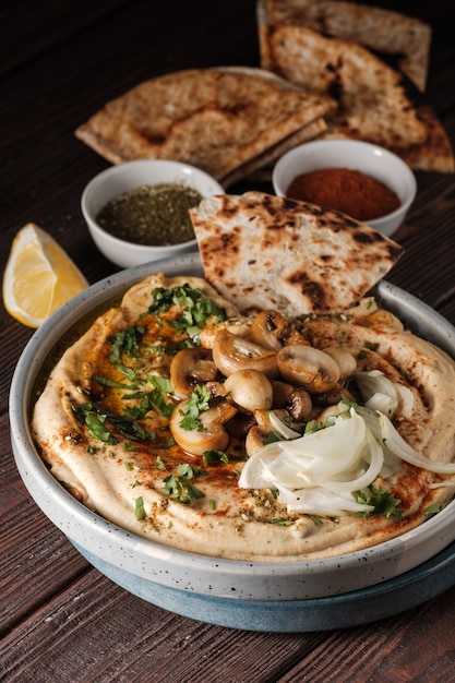 Traditioneller mediterraner Hummus mit Pilzen und Zwiebeln.