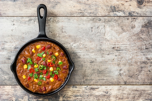 Traditioneller Mexikaner Tex Mex Chili con Carne in einer Bratpfanne auf Holztischebenenlage